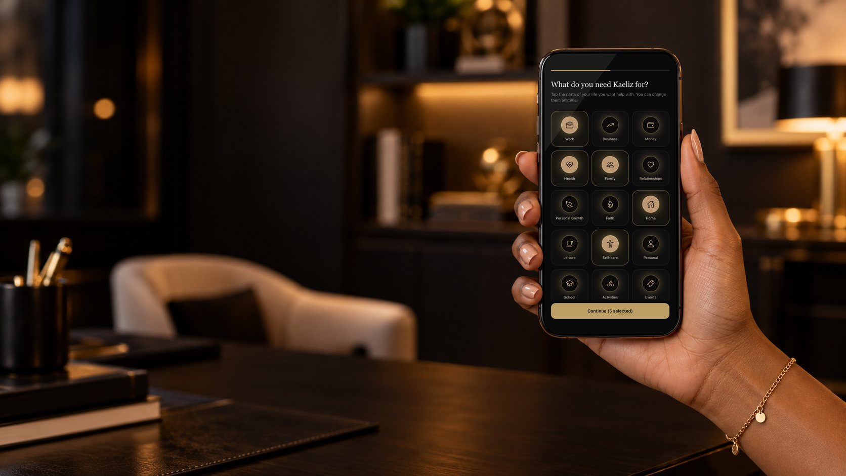 A hand holding a phone showing the Kaeliz setup screen: What do you need Kaeliz for, with life areas like Work, Health, Family, Home and Self-care